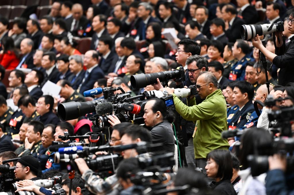 3月8日，十四屆全國人大二次會議在北京人民大會堂舉行第二次全體會議。這是記者在會議現(xiàn)場采訪。新華社記者 牟宇 攝